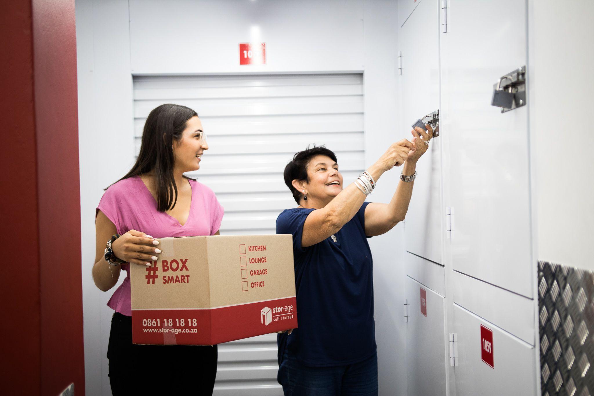 Customers unlocking a locker storage unit to place storage box inside.