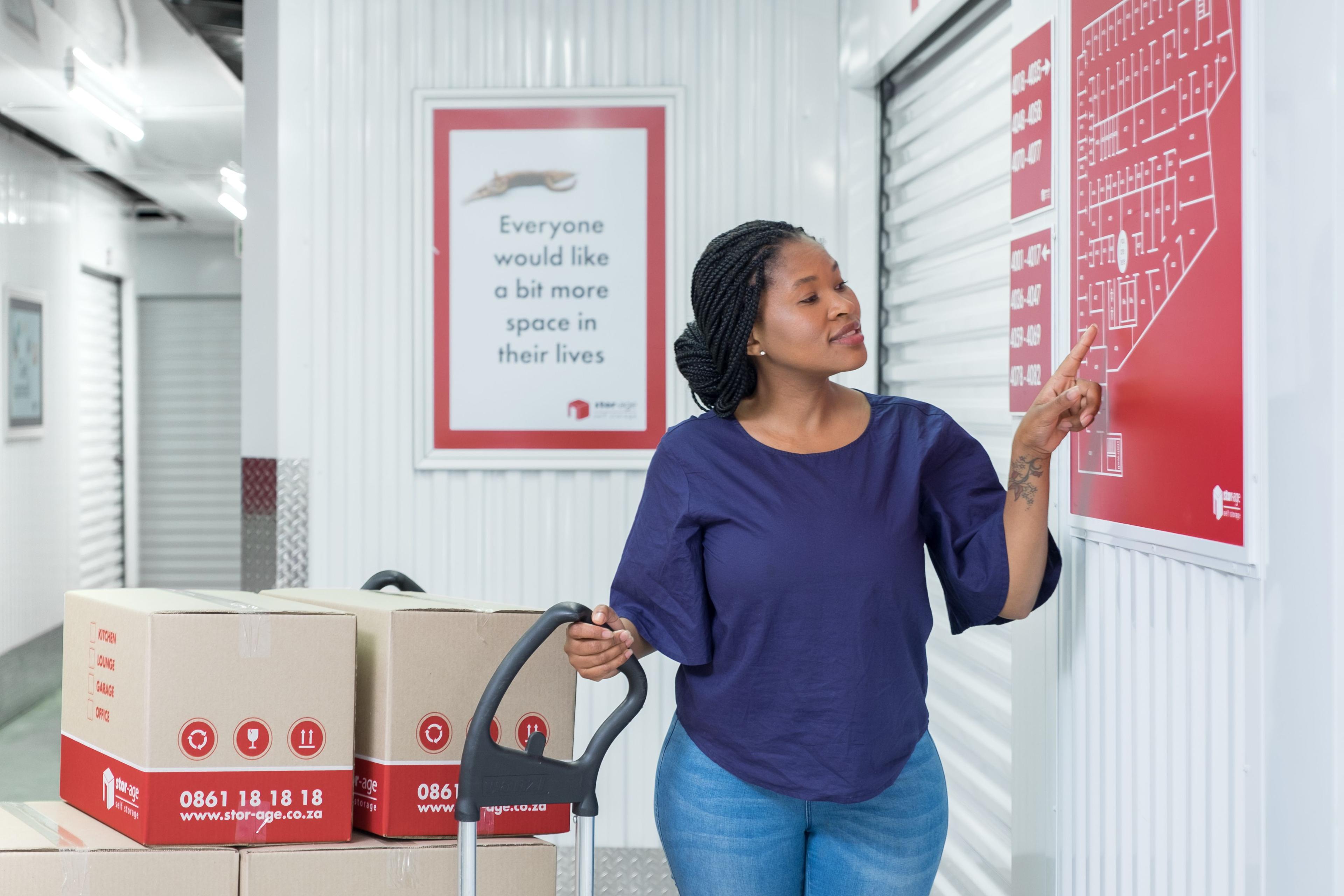 Customer with boxes on trolley looking for their storage unit on the facility map.